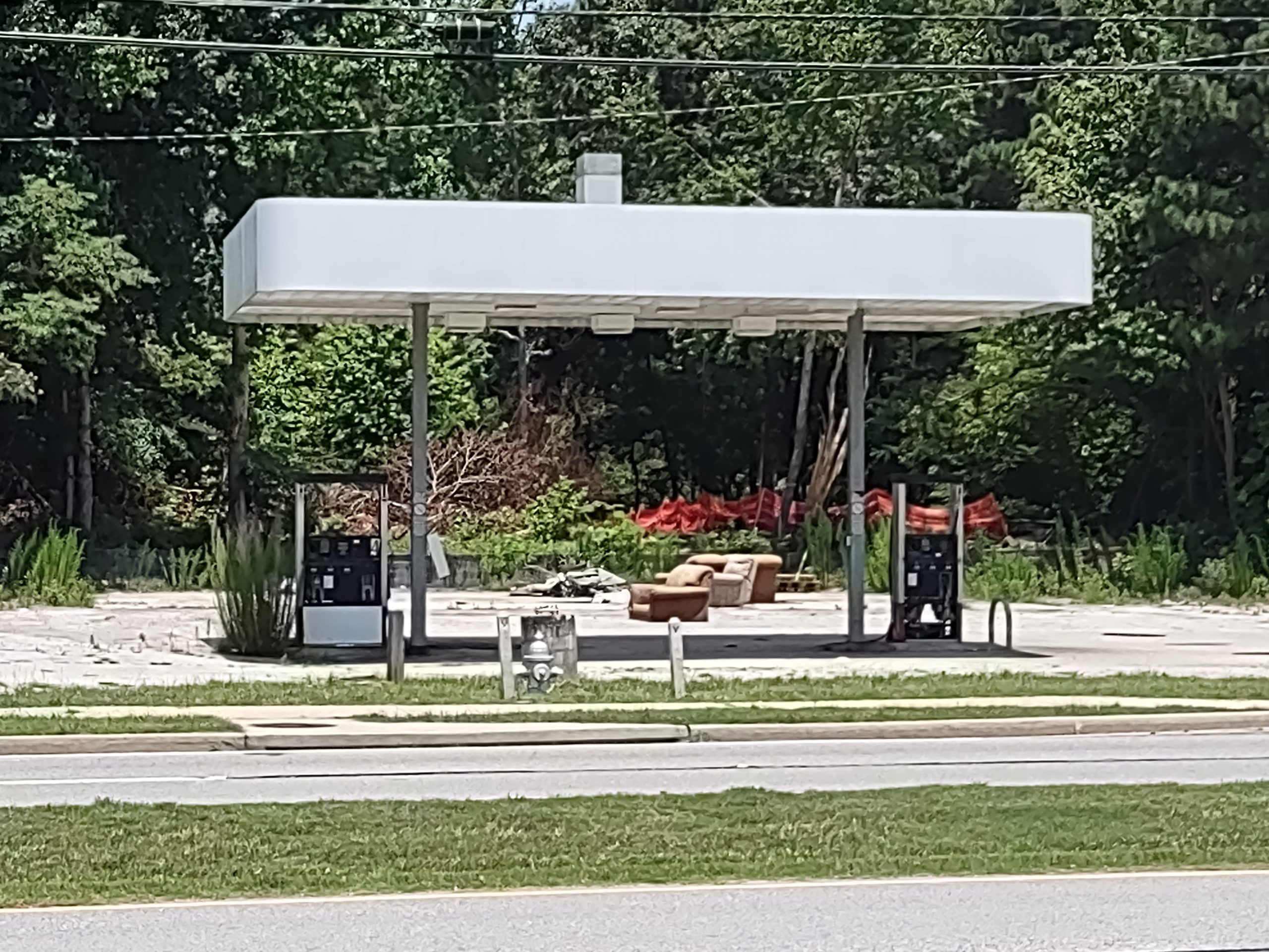 Picture of the abandoned gas pumps, awning, and couches that inspired the post.